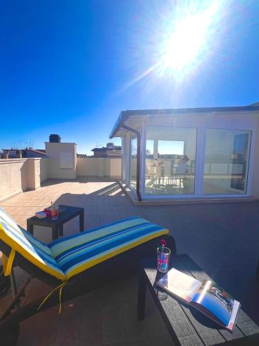 a balcony with a bed and a table on a roof at ROMA AIRPORT SKY Apartments in Fiumicino