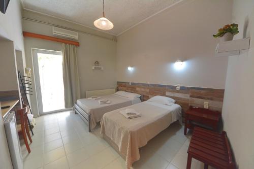 a hotel room with two beds and a window at Bikakis Family Apartments in Kissamos