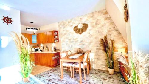a kitchen with a table and some plants in a room at Baltic Del Mar by Baltic Batavia-Widok na Morze in Świnoujście