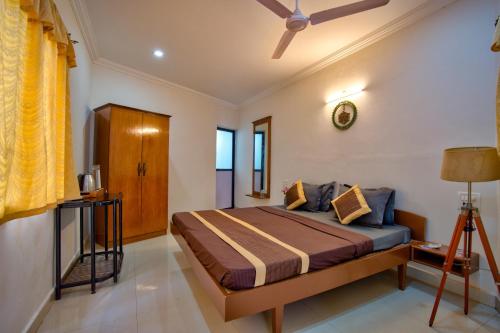 a bedroom with a bed and a ceiling fan at Papilio Beach Front Cottages-TBV in Baga