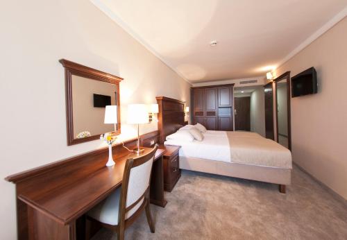 a hotel room with a bed and a desk with a desk at Grand Hotel Neum Wellness & Spa in Neum