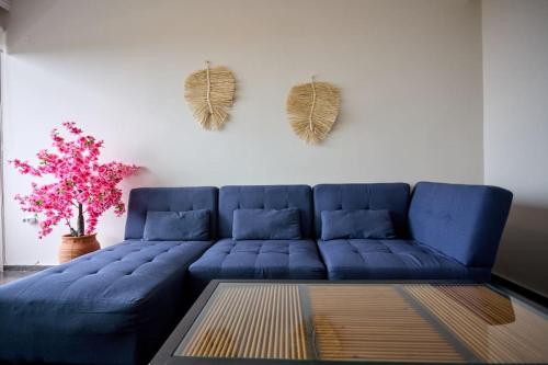 a blue couch in a living room with a plant at Panoramic White Blue in Chios