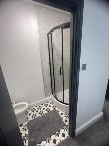a bathroom with a toilet and a glass door at Town Centre En Suite Room 1 in Barnstaple