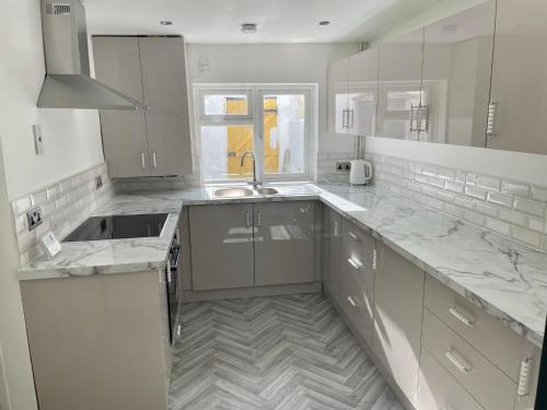 a kitchen with marble counter tops and a sink at Town Centre En Suite Room 1 in Barnstaple