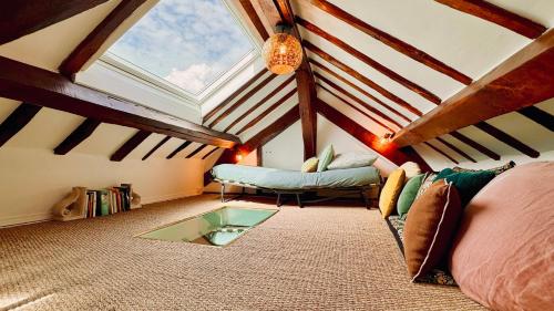 une chambre mansardée avec un canapé et une table en verre dans l'établissement Charmant T2 en coeur de ville 15min de Disney, à Lagny-sur-Marne
