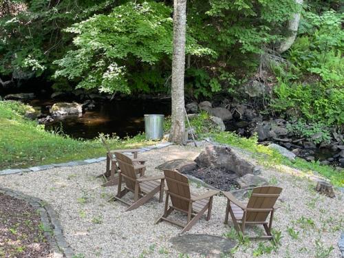 a picnic table and chairs next to a fire pit at The Snowed Inn in Killington