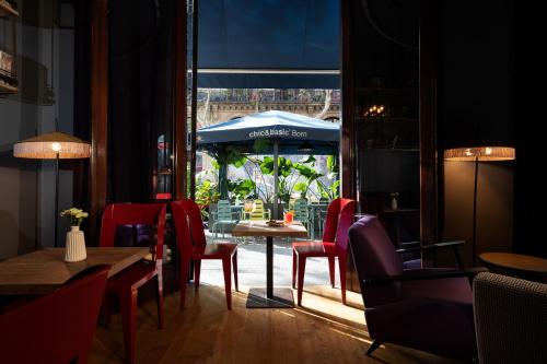a restaurant with a table and chairs and an umbrella at Chic & Basic Born Boutique Hotel in Barcelona