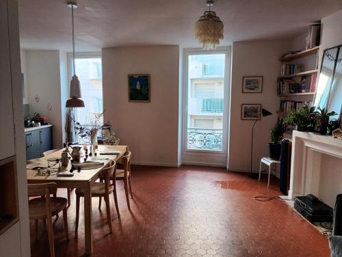 une salle à manger avec une table et des chaises et une cheminée dans l'établissement Grand T3 Breteuil, à Marseille