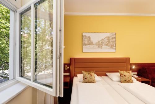 a bedroom with two beds and a window at Austria Classic Hotel Wien in Vienna