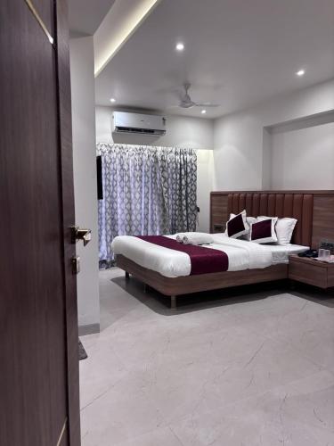 a bedroom with two beds and a television in it at Sai Ram Regency in Bhayandar