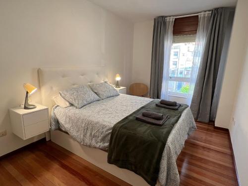 ÁngelesにあるApartamento Porta de Fisterraのベッドと窓のある白い寝室