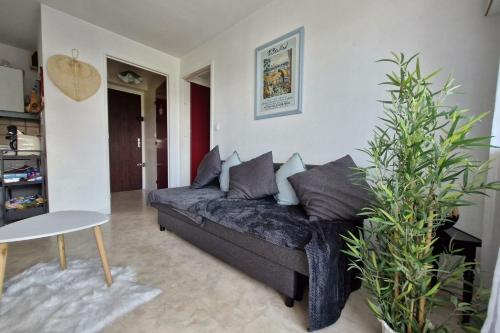 un salon avec un canapé et une table dans l'établissement Comfortable two-room nest with sea view, à Villers-sur-Mer