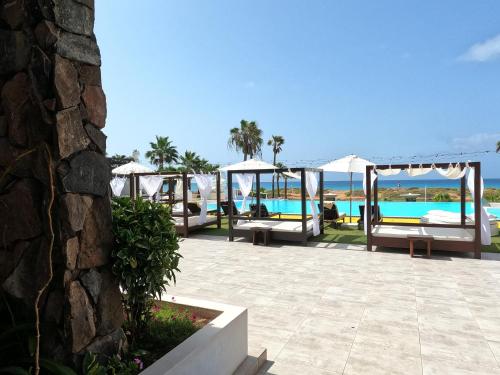 a patio with beds and a view of the ocean at Hotel LIVVO Budha Beach in Santa Maria