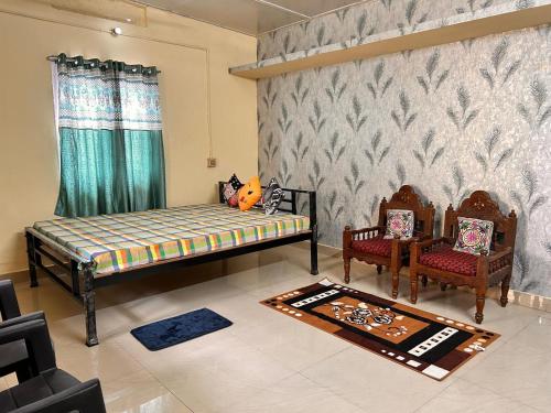 a living room with two beds and two chairs at Abhigyanam Home Stay in Guwahati
