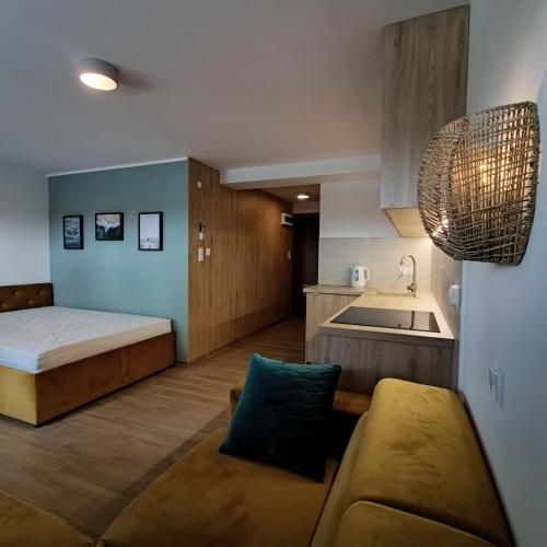 a small room with a bed and a kitchen at Willa na Orlej in Giewartów