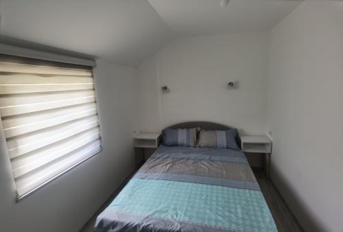 a small bedroom with a bed and a window at Apartmani Račanka in Bajina Bašta