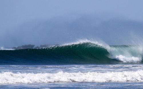 a large wave in the ocean on a cloudy day at Olas Verdes Hotel in Nosara