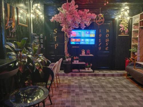 a room with a table and some plants and a screen at STPhostel in Patong Beach