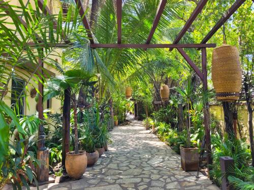 a garden with palm trees and a pathway at La Villa Boutique Hotel in Accra
