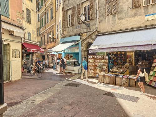 Un groupe de personnes se promenant dans une rue avec des magasins dans l'établissement Charming Appartment Old City, à Nice