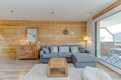 un salon avec un canapé bleu et une table dans l'établissement Homency - Résidence Azur G5, à L'Alpe-d'Huez