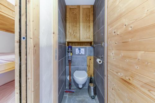 une salle de bain avec toilettes dans une pièce aux murs en bois dans l'établissement Homency - Résidence Azur G5, à L'Alpe-d'Huez