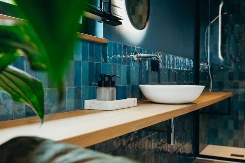 a bathroom with a sink and blue tiles at Madame Crepin in Rochefort