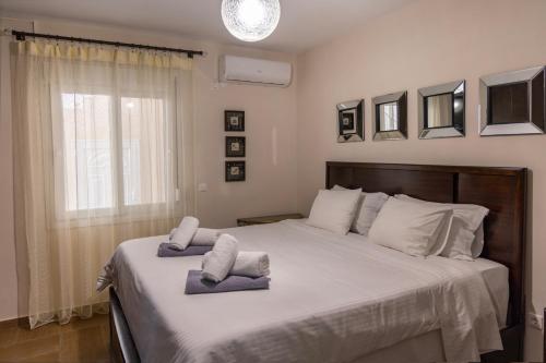 een slaapkamer met een groot bed met handdoeken erop bij Limani Lux Apartments in Karpathos