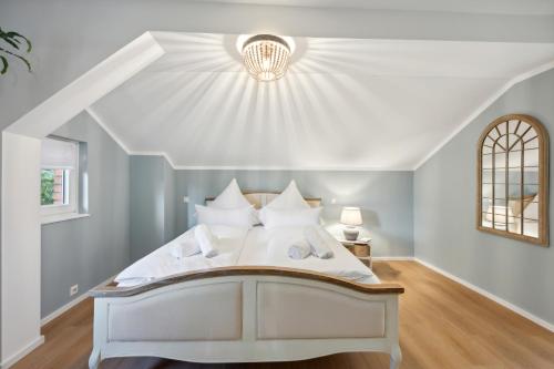 un letto bianco in una stanza con soffitto bianco di Altstadt Apartment am Wasser mit großem Garten a Bad Kreuznach
