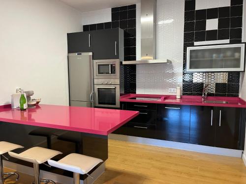a kitchen with a red counter top and appliances at Casa La Oliva Vejer in Vejer de la Frontera