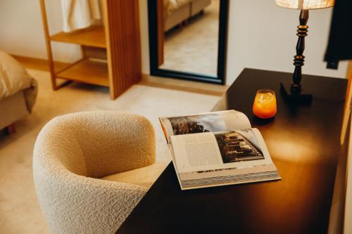 a book on a table next to a chair on a desk at Madame Crepin in Rochefort