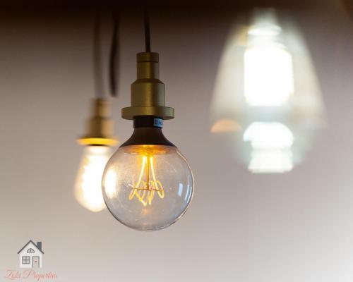 a group of light bulbs hanging from a ceiling at ACME Apartments in Budapest