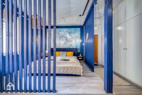 a blue bedroom with a bed and a blue wall at ACME Apartments in Budapest