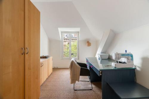 Cette chambre dispose d'un bureau avec une machine à coudre. dans l'établissement Charmante Maison au Raincy, à Le Raincy
