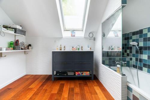 une salle de bain avec une vanité noire et une fenêtre dans l'établissement Charmante Maison au Raincy, à Le Raincy