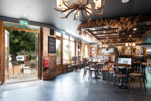 a restaurant with tables and chairs and a chandelier at Wateredge Inn- The Inn Collection Group in Ambleside