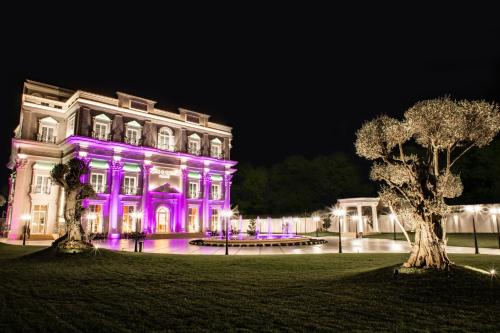 a building with purple lights on it at night at King & Queen Boutique Hotel in Fier