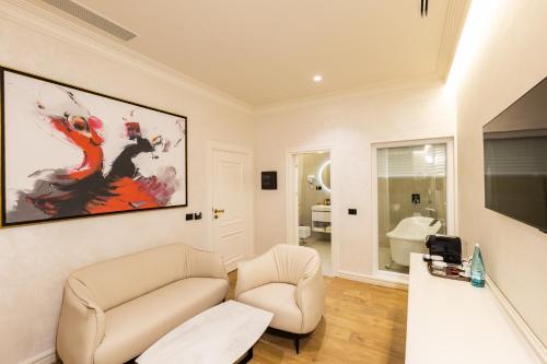 a living room with a couch and a painting on the wall at King & Queen Boutique Hotel in Fier