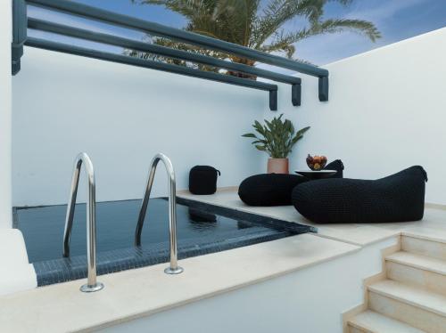a swimming pool in a house with metal faucets at Asty Mykonos Hotel & Spa - World of One Hotel Group in Mýkonos City