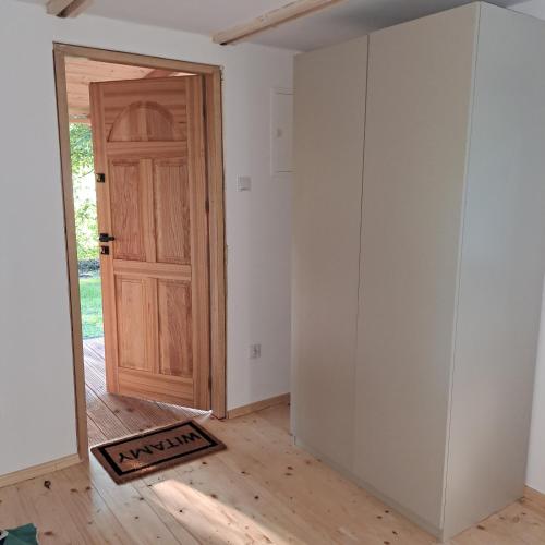 an empty room with a wooden door and a floor at Domek nad Kanałem Augustowskim Stanica Wodna PTTK Płaska in Płaska