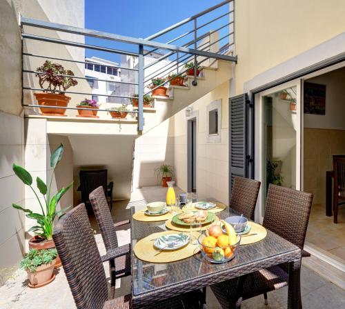 a table with a bowl of fruit on a balcony at City center, private parking, AC, 6ppl. in Olhão