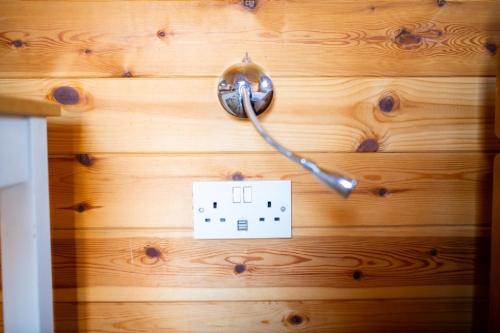 a wooden door with a light switch on it at Camping Pods Trevella Holiday Park in Crantock