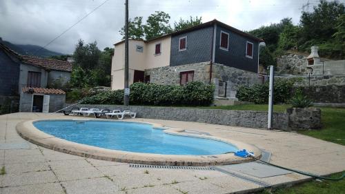 a swimming pool in a yard next to a house at Casa do Moinho in Resende