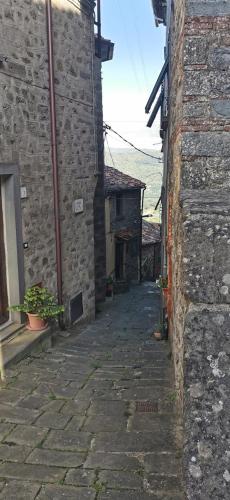 an alley in an old stone building with a building at Da Arturo e Maruca suites con 2 camere in Vellano