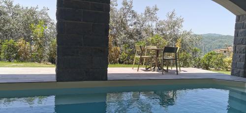 a table and two chairs next to a swimming pool at Da Arturo e Maruca suites con 2 camere in Vellano