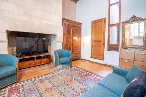 un salon avec deux chaises bleues et une télévision dans l'établissement Le Typique Tourangeau, à Tours