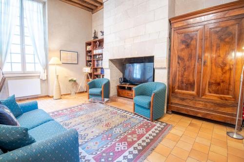 un salon avec deux chaises bleues et une télévision dans l'établissement Le Typique Tourangeau, à Tours