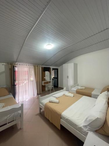 a large room with two beds and a table at Vogue Rooms in Golem