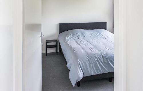 a bedroom with a bed with a white bedspread and a table at Gorgeous Home In Ijhorst With Kitchen in IJhorst