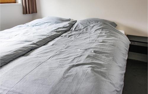 a bed is covered with a gray blanket at Gorgeous Home In Ijhorst With Kitchen in IJhorst